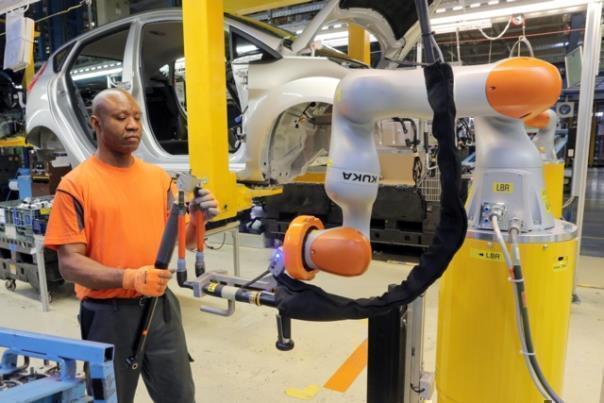 Arbeiten Hand in Hand: Kollaborierende Leichtbauroboter übernehmen bei der Stoßdämpfer-Montage in der Ford Fiesta-Fertigung in Köln die Überkopfarbeit. 